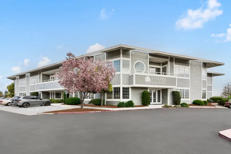 3190 S Bascom Ave, a two-story office building with a flowering tree beside the parking lot
